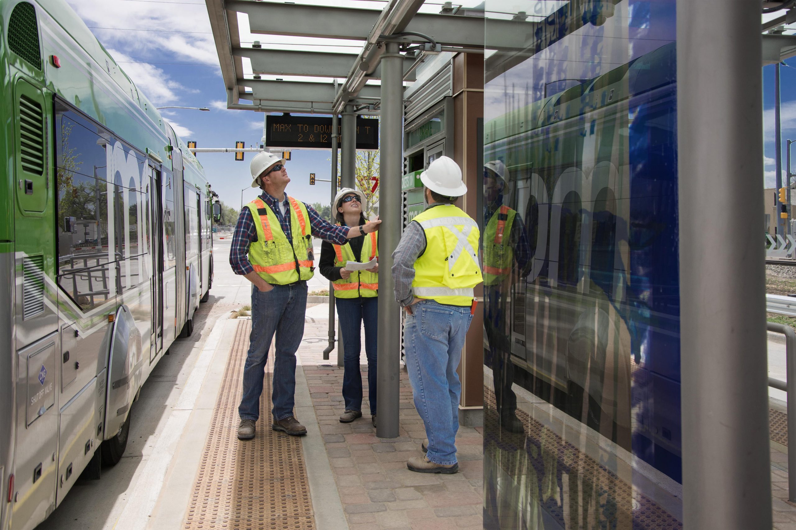 Image of construction workers inspecting bus stop structure